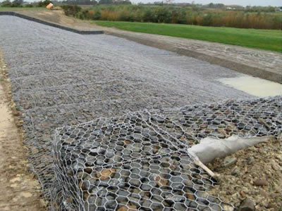 Galvanized gabion baskets filled with stones are placed together neatly.