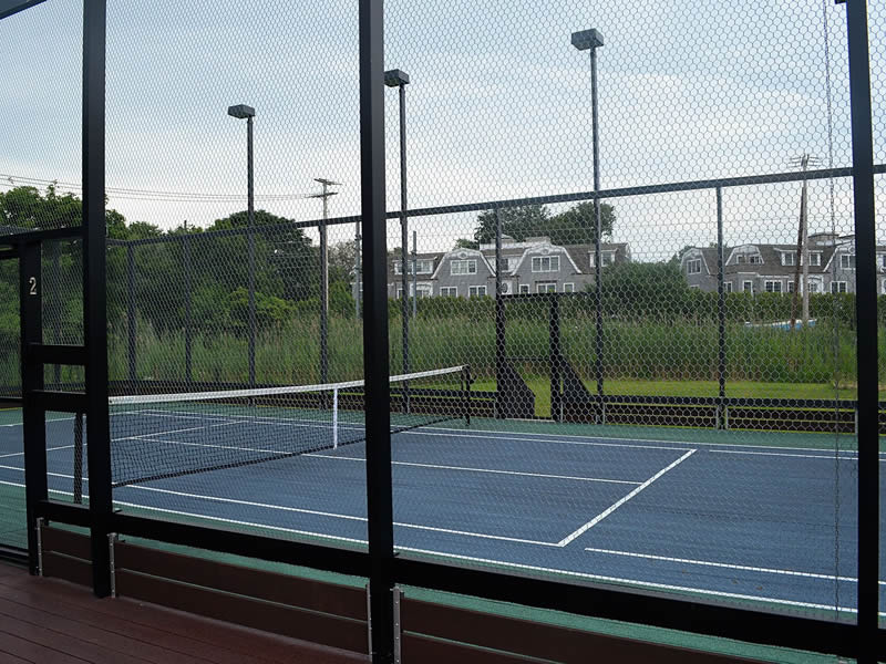 A part of platform tennis court with door is exhibited, hexagonal wire mesh is fixed in posts and doors.