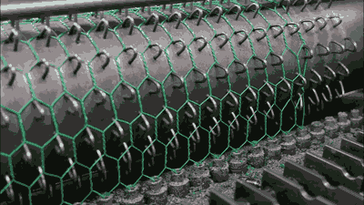 Green PVC coated hexagonal wire mesh is producing by machine.